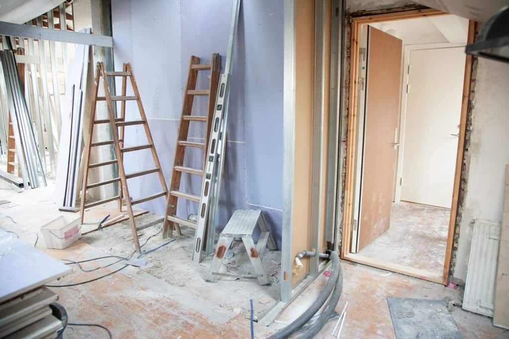 דירה בשיפוץ עם סולמות וכלי עבודה לפני פתיחת פתח בקיר